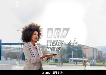 Businesswoman looking at mobile app coming through mobile phone in city Stock Photo