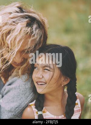 Playful daughter winking at mother Stock Photo