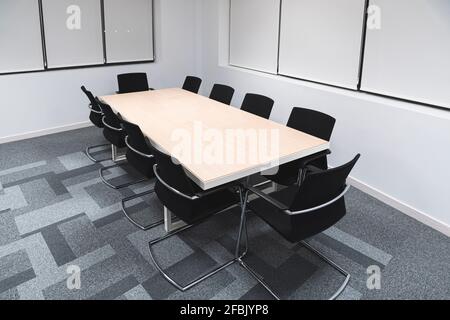 Black office chairs arranged around conference table in board room at work place Stock Photo