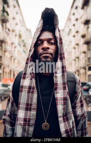 Confident young man in hooded jacket Stock Photo