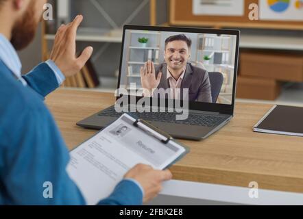 Smiling employer or hiring manager greeting job candidate in virtual job interview Stock Photo