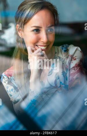 Contemplating beautiful woman looking away at home Stock Photo