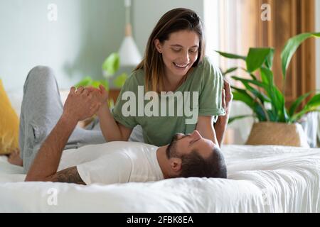 Playful young couple embracing each other on bed at home Stock Photo