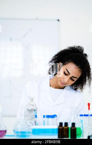 Young researcher injecting liquid in test tube at laboratory Stock Photo