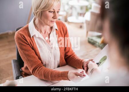Businesswoman discussing with female colleague over graph data in home office Stock Photo