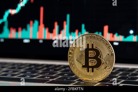 Gold colored bitcoin on laptop Stock Photo