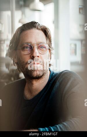 Thoughtful male owner looking away in cafe Stock Photo