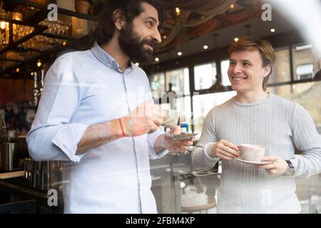 Male coworkers having coffee during break time at office Stock Photo