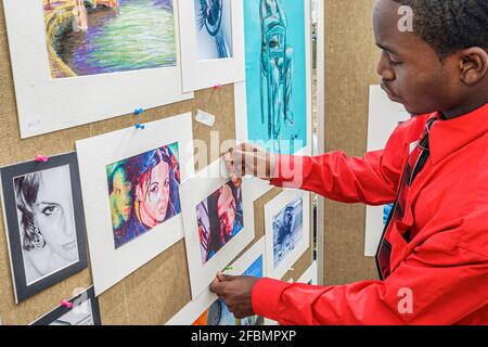 Miami Florida,Coconut Grove Arts Festival,festivals fair event community,Black high school artist boy art student hanging artwork,teen teenage teenage Stock Photo