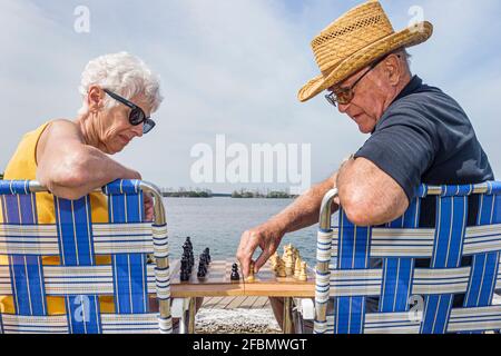 Miami Florida,Homestead Biscayne National Park,Biscayne Bay senior seniors citizen citizens couple,lawn chairs play playing chess, Stock Photo