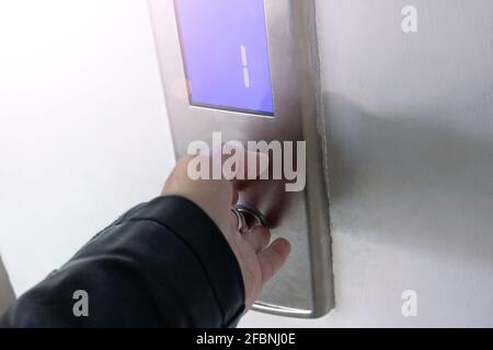 Hand presses the gray elevator button close up Stock Photo