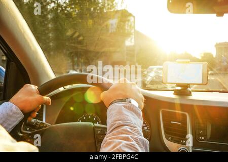 Directions on cell phone in phone holder mount on dashboard dash panel surface, expensive vehicle interior. Gps route navigation concept. Young man ha Stock Photo