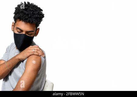 TEENAGER BEING VACCINATED WEARING A FACE MASK. COVID-19