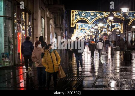 BELGRADE, SERBIA - JULY 21, 2020: Selective blur on two Women, young girl and old woman, walking at night wearing face mask respiration protective equ Stock Photo