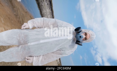 Man in protective suit and respirator looks at a white rat . vertical shot  Stock Video Footage by ©expsycholog.gmail.com #349075634
