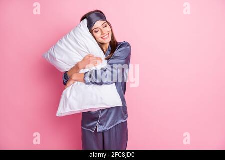 Photo portrait of gorgeous girl hugging pillow with closed eyes isolated on pastel pink colored background Stock Photo