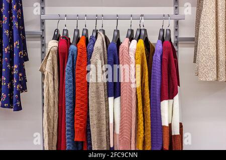 Different casual clothes hanging in the retail clothing store. Stock Photo
