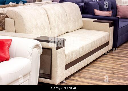 Big comfortable beige sofa in the luxury furniture store. Stock Photo