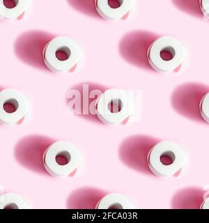 White toilet paper roll repeat seamless pattern on light pink background. Stock Photo