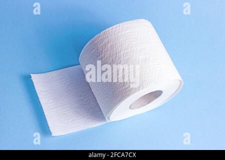 White toilet paper roll on light blue background. Stock Photo