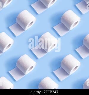 White toilet paper roll repeat seamless pattern on light blue background. Stock Photo