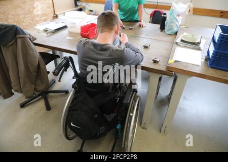 Gera, Germany. 23rd Apr, 2021. A man in a wheelchair works in the metal department of Lebenshilfe Gera e.V., where he makes threaded parts. Workshops for people with disabilities hope for better support. Credit: Bodo Schackow/dpa-Zentralbild/dpa/Ģ����ý Live News Stock Photo