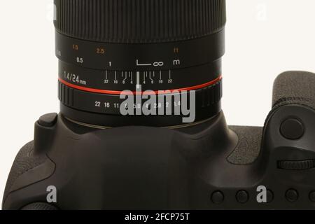 The aperture and focus rings are shown on the barrel of a modern DSLR camera lens, shown isolated in a macro closeup view. Stock Photo
