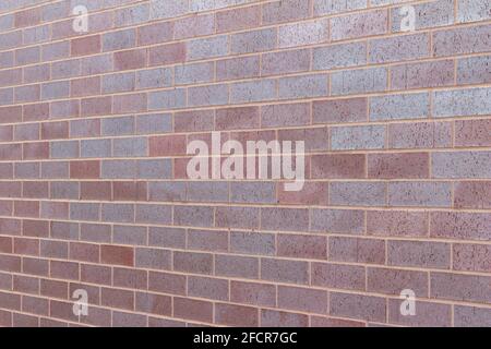 Title Vintage magenta color brick wall texture background in a 1/3 offset stretcher bond pattern, with bricks in varying shades of red and blue Stock Photo