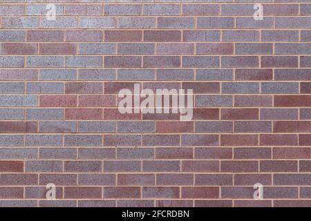 Title	 Vintage magenta color brick wall texture background in a 1/3 offset stretcher bond pattern, with bricks in varying shades of red and blue Stock Photo