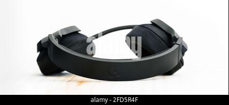 Galle, Sri Lanka - 02 18 2021: Logitech G433 gaming headset lying ear cups down on the wooden computer table against a white background. Stock Photo