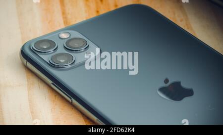 Galle, Sri Lanka - 02 19 2021: Apple iPhone 11 pro max smart mobile device on a wooden table backside close-up photograph. Dark glossy greyish Apple l Stock Photo