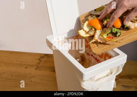a man as he throws the organic waste into the bin Stock Photo