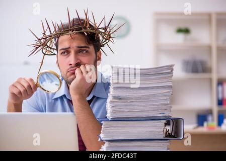 Young businessman employee wearing prickly wreath on head Stock Photo