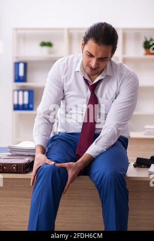 Young male employee feeling bad at workplace Stock Photo