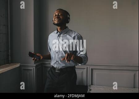 an African American with headphones listening to music and enjoying and slowly dancing Stock Photo