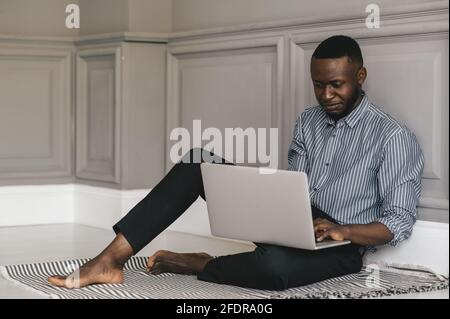 serious black male student looking at laptop listening lecture study online on computer e learning Stock Photo