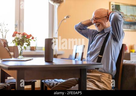 Senior man using Virtual Assistant at home Stock Photo