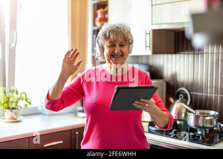 Happy senior woman using digital tablet at home Stock Photo
