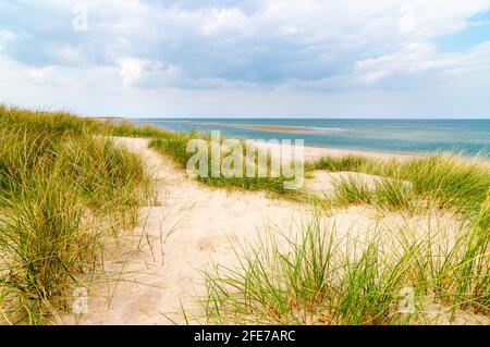 A sand bank appearing along a sandy beach with marram grass growing on the edge of the beach, at Burnham Overy Staith, Norfolk, UK. Stock Photo