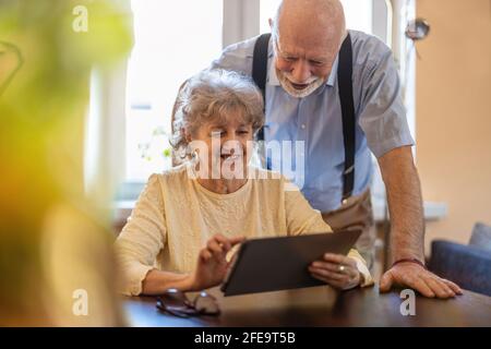Happy senior couple using digital tablet at home Stock Photo