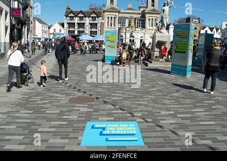 market square of kingston upon thames, surrey, england, with stencilled  promotional pavement marking reading keep your ear to the ground in kingston Stock Photo