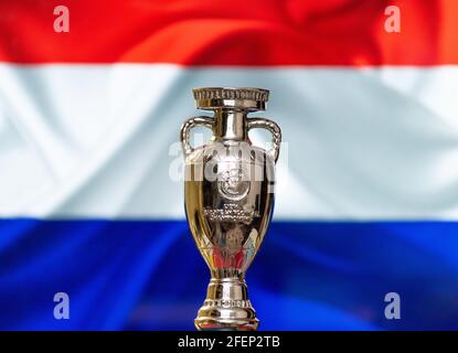 April 10, 2021. Amsterdam, Holland. UEFA European Championship Cup with the Netherlands flag in the background. Stock Photo