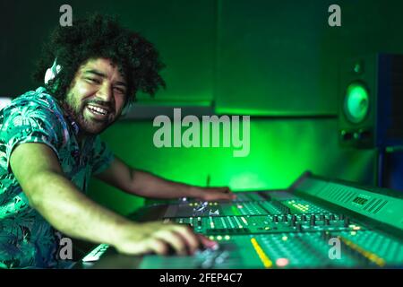 Young Afro man working in music recording studio - Male audio engineer mixing a sound in production house Stock Photo
