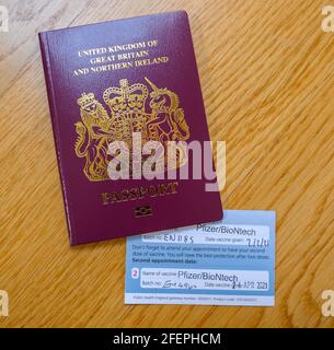 London, UK. 24 April 2021. Vaccine certificate issued by NHS UK with second Pfizer/BioNtech vaccination stamped, certificate tucked inside passport. Half the UK population is reported to have now received the first vaccine. Credit: Malcolm Park/Alamy Live News. Stock Photo