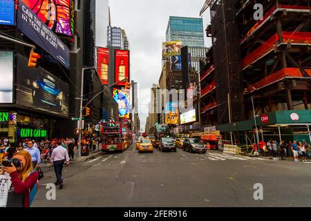 The traffic and people at Times Square on a busy summer evening with tourists around Stock Photo
