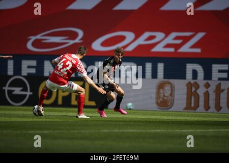 Mainz, Germany. 24th Apr, 2021. Football: Bundesliga, FSV Mainz 05 - Bayern Munich, Matchday 31 at Opel Arena. Mainz' defender Alexander Hack (l) and Munich's midfielder Thomas Müller (r) IMPORTANT NOTE: In accordance with the requirements of the DFL Deutsche Fußball Liga and the DFB Deutscher Fußball-Bund, it is prohibited to exploit or have exploited photographs taken in the stadium and/or of the match in the form of sequence pictures and/or video-like photo series. Credit: Tom Weller/dpa-Pool/dpa/Alamy Live News Stock Photo