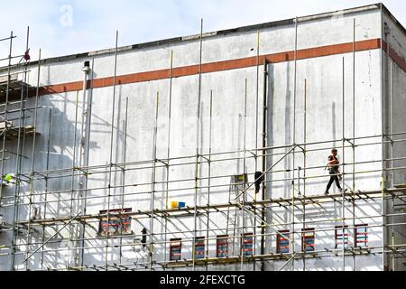 Pontypridd, Wales - April 2021: Worker walking across a platform on scaffolding around the old County Cinema in Pontypridd town centre. Stock Photo