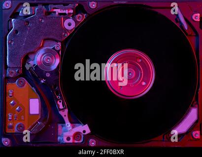 Close up view of a computer hard drive with red-blue lighting.