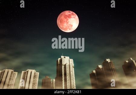 Cityscape at night time with fogy and darkness sky super moon full of many stars.The moon taken with my camera. Stock Photo