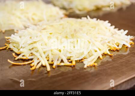 A pile of shredded potatoes, hashbrowns, cook on a commercial flat grill in a diner. Stock Photo